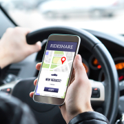 Ride share driver in car using the rideshare app in mobile phone. New taxi ride request from customer in smartphone application.