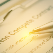 Legal form concept : Blue pen and a non compete contract on a clipboard. Noncompete contract is an agreement between employee and employer, not to enter into competition in subsequence business effort